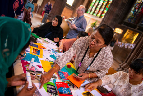 Tutor showing a group how to make a card